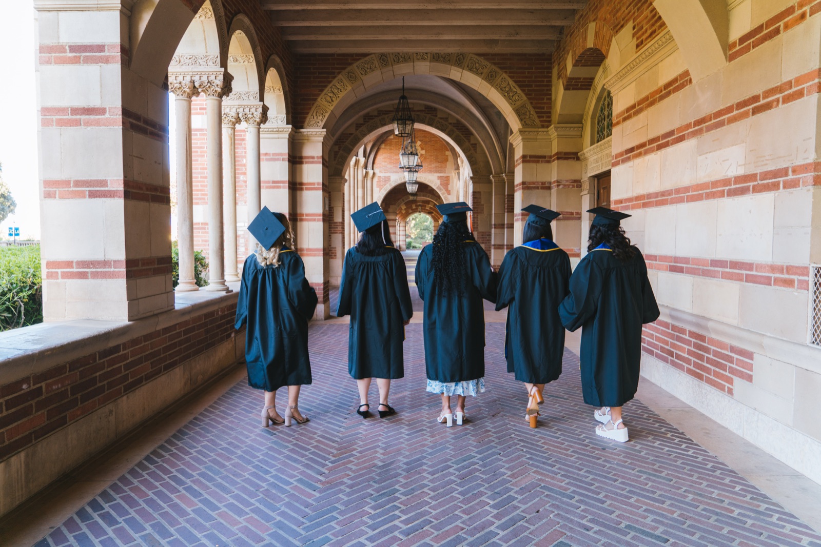 Graduates walking together through a university arcade